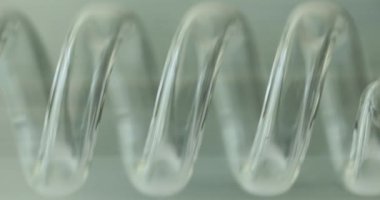 Beyaz arka planda spiral şeffaf plastik laboratuvar ekipmanı tüpü. Kimyasal reaktörü incelemek için küçük bir detay. Ayrı nesne