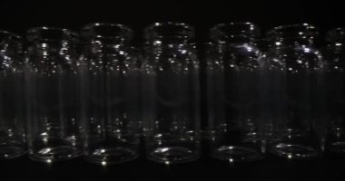 Large number of empty glass vials for vaccines stands in rows in dark premise. Professional glassware for medical purposes and laboratory investigations