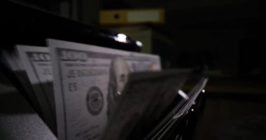 Bill counter operates with dollar banknotes in dark office. Counting money in banking institution. Modern technologies and replacement of accountant slow motion