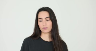 Esmer, uzun siyah saçlı kadın beyaz arka planda yüz ifadeleri sergiliyor. Güzel bir kadın mutluluğun altını çizer. Flört eder ve şaşırır.