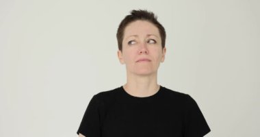 Kısa saçlı bir kadın beyaz arka planda rahatsız edici bakışlar atıyor. Duygusal bayan yüz ifadesiyle hayal kırıklığı yaratıyor.