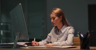 Kadın çalışan geç saatlere kadar çalışırken, erkek iş arkadaşı dosya yığınını ofise koyuyor. Yorgun kadın işyerindeki yeni acil işlerden dolayı şok oldu
