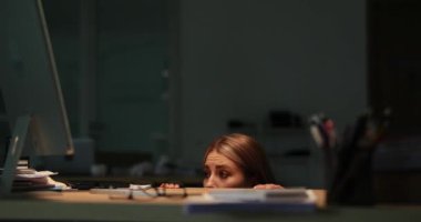 Korkak kadın, korkunç fırtına sırasında masanın altına saklanıyor. Duygusal kadın iş yerinde yalnız kalarak stres ve baskı gösterir.