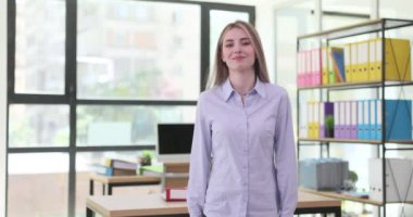 Modern ofiste kendine güveni tam bir kadın. Neşeli yüz ifadesiyle gülümseyen genç kadın iş toplantısına hazırlanıyor.