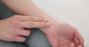 Kadın koltukta oturmuş nabzını kontrol ediyor. Özenli kadın, sabahları sağlık durumunu gözlemliyor.