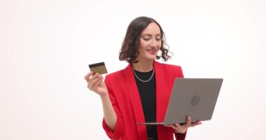 Kadın ofis çalışanı beyaz arka planda kredi kartı ve laptop tutuyor. Kadın modeli çevrimiçi alışveriş ve dijital işlemler gerçekleştiriyor