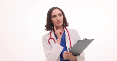 Düşünceli kadın doktor beyaz arka planda fikir üretimini gösteren işaret parmağını kaldırdı. Steteskoplu sıhhiyede plaklı pano var