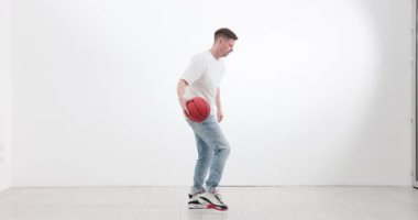 Sporcu jimnastik salonunda zıplayan basketbol topuyla meşgul olur. Konsantre genç adam yarışmadan önce oyun tekniğini geliştirir