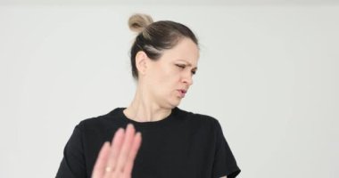 Kadın reddedilme hareketlerini beyaz arka planda el işaretleriyle yapar. Duygusal bayan açık bir anlaşmazlık ve güçlü bir reddetme mesajı iletiyor