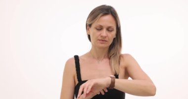 Sabırsız kadın kol saatine bakar ve beyaz arka planda erkek arkadaşını bekler. Dişi, arkadaşına gelmesi için biraz daha zaman tanımaya karar verir.
