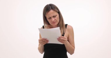 Ciddi kadın, beyaz arka plandaki önemli belgeleri titizlikle inceler. Kadın metnin nüanslarını anlamak için kağıtları dikkatle analiz eder
