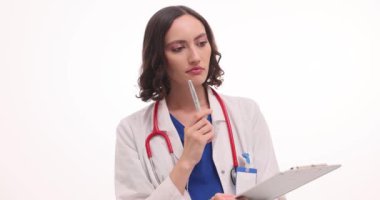 Üniformalı kadın doktor beyaz pano tutarak not alıyor. Odaklanmış kadın terapist, hasta için verimli tedavi seçenekleri düşünüyor