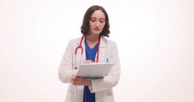 Üniformalı kadın doktor beyaz hastayı dinlerken notlar alıyor. Steteskop kullanan sıhhiye hastanedeki tıbbi bilgileri kaydetti.