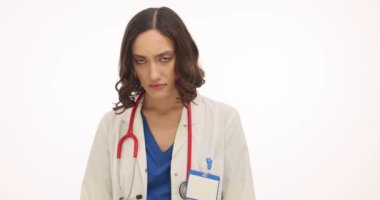 Steteskoplu kadın doktor, beyaz arka planda üzüntü ve endişe ifade ediyor. Boş rozetli kadın pratisyen hekim gözyaşlarını sildi