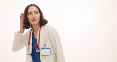 Üniformalı kadın doktor beyaz arka planda el ele tutuşan sırları dinler. Meslektaşları dedikodulara ilgi gösteriyor.