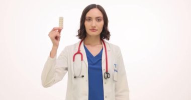 Kadın jinekologlar beyazlara karşı hap ve prezervatif gösteriyor. Üniformalı kadın doktor, randevuda hastaya istenmeyen hamileliğe karşı doğum kontrol seçenekleri sunuyor