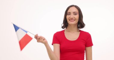 Kırmızı gömlekli esmer kadın beyaz arka planda Fransız bayrağı sallıyor. Ulusal bayram kutlamalarında gülümseyen genç bir kadın.