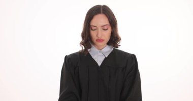 Siyah cüppeli kadın yargıç beyazlara karşı elleri kelepçeli görünüyor. Hukukta profesyonel suç ve ceza kavramı