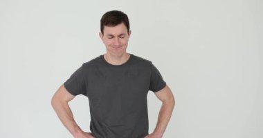 Günlük kıyafetli bir adam, beyaz arka planda inançsızlık göstergesi olarak başını sallıyor. Şüpheli erkek, mimik ve jest yaparak inkar ediyor.