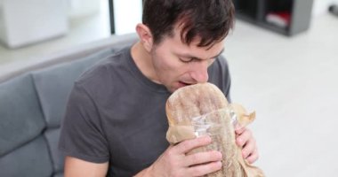 Adam ofis odasındaki koltukta oturan taze ekmek kokusundan hoşlanıyor. Aç adam hamur işi yer zevkin tadını çıkarır dinlenmeye zaman ayırır.