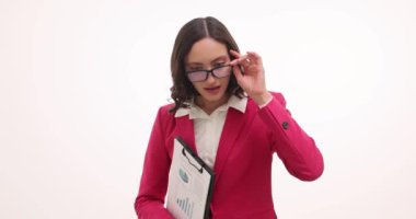 Genç iş kadını beyaz arka planda değerlendirmeli bakışlarla hoparlöre bakıyor. Çekici bir kadın, her şeye burnunu sokan bir iş ortağını hor görüyor.