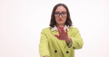 Ciddi iş kadını beyaz arka planda reddedildiğini göstermek için kollarını kavuşturuyor. Parlak ceketli çekici kadın tartışmaya katılmayı reddediyor.