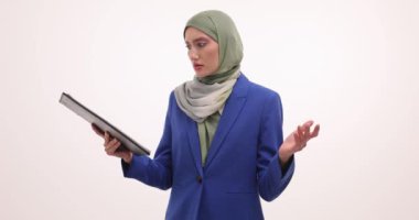 Kafası karışmış tesettürlü kadın beyaz arka planda kafaya dokunan bir pano tutuyor. Müslüman kadın yönetici ofiste hayal kırıklığı yaşıyor