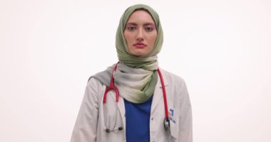 Başörtüsü takan kadın doktor beyaz arka planda pembe kurdele sembolü gösteriyor. Müslüman sıhhiyeci, meme kanserinin sağlıklı yaşam tarzını teşvik ettiğini hatırlattı