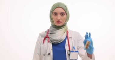 Türbanlı kadın doktor tahta küplerden ve beyaz arka planda kan olan test tüplerinden HPV gösteriyor. Müslüman doktor teşhis sürecini açıkladı