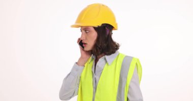 Kızgın kadın inşaat işçisi telefonda müteahhitle konuşuyor. Kadın çalışan konuşma sırasında olumsuz duygular ifade ediyor
