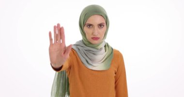 Odaklanmış ifadesi olan Müslüman kadın el kaldırıyor. Arap kadın beyaz arka planda güçlü bir reddetme işareti gösteriyor.