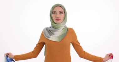 Müslüman kadın beyaz arka planda ulusal Amerikan bayrağını göndere çekiyor. Türbanlı Arap kadın ABD vatandaşlığına minnettarlığını ifade ediyor