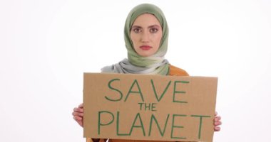 Beyaz arka planda tesettürlü Arap kadın Save Planet afişini kaldırıyor. Müslüman kadınlar, savaş sonrası ekoloji ve çevre korumasını hatırlatıyor.