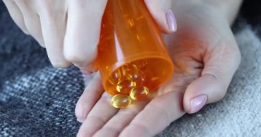 Kişi eline temiz sarı haplar döker. Marihuana yağı veya Omega 3 vitamini konsepti