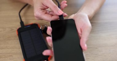Kadın dış bataryadan akıllı telefonu şarj ediyor. Taşınabilir pil güç bankası kavramı