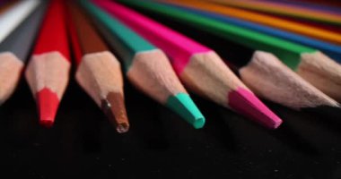 Siyah arkaplana çizim yapmak için çeşitli renkli kalemler. Farklı renkler çizmek için renkli kalemler