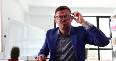 Kızgın işadamı çığlık atıyor ve ofisteki kamerayı işaret ediyor. Saldırgan patronun çalışanlara bağırıp azarlamasının portresi.