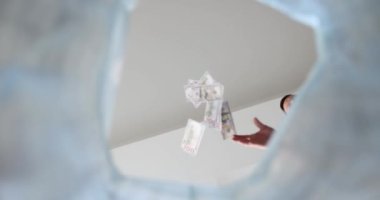 Adamın biri çöp torbasına dolar atıyor, yakın plan. Enflasyondaki yüksek büyüme, konsept, statik çekim