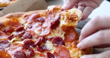 Kadın eli sıcak pizzadan bir parça koparır. Gıda teslimatı konsepti