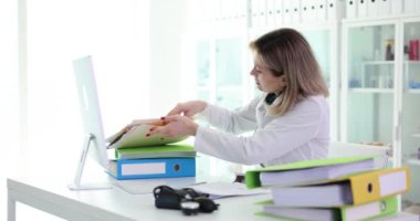 Doktor çalışıyor ve klinikte tıbbi belgeler arıyor. Tıbbi belgeler ve dizinler
