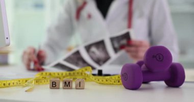 Dambılları ölçmek için bant ve tahta blokta BMI ve doktor kelimeleri. Diyet ve uygun beslenme