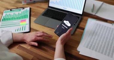 Cep telefonuna bulut indiren yakın plan kadın eli. Çalışma dosyaları kaydediliyor ve belgeler yükleniyor