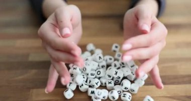 Avuçlarında harfler olan beyaz küpler masanın üzerine dökülüyor. Alfabe öğrenme ve okuma zorluğu