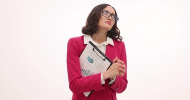 Pembe resmi ceketli iş kadını elinde el çırpan grafiklerle pano tutuyor. Gergin kadın, beyaz arka planda duygusal bir heyecan hissediyor