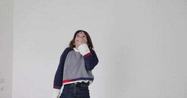 Küçük kız, beyaz arka planda avuçlarıyla ağzını kapatırken güçlü bir şok yaşıyor. Korkmuş çocuk puanları ekşitme ve jestlerle stres gösteriyor