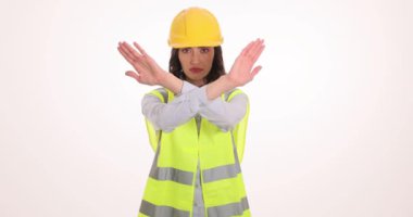 Miğferli kızgın kadın beyaz arka planda el hareketlerini gösteriyor. Üniformalı genç bayan mühendis evlenme teklifiyle anlaşmazlık gösteriyor.