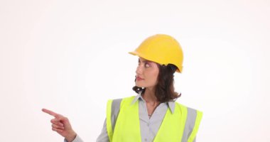 Beyaz arka planda parmağı olan miğfer başlıklı kadın mühendis. Güvenlik yeleği giyen kadın işçi, ortakların uyarısına proje detaylarını açıklıyor