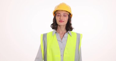 Miğfer dalgaları içindeki neşeli kadın mühendis beyaz arka planda el ele karşılama ekibi. Hoş gülüşü olan genç bir kadın olumlu bir tavır sergiliyor.