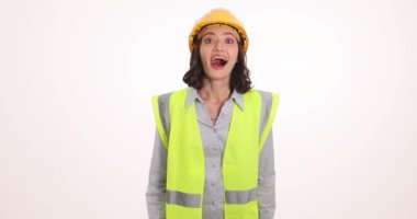 Miğfer ve güvenlik yeleği giyen mutlu kadın mühendis projeden memnun olduğunu ifade ediyor. Yüzünde neşeli bir ifade olan üniformalı genç bir kadın.