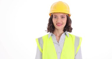 Gülümseyen kadın mühendis beyaz arka plana güvenlik gözlüğü takıyor. Üniformalı neşeli kadın inşaat alanında çalışmaya hazırlanıyor.